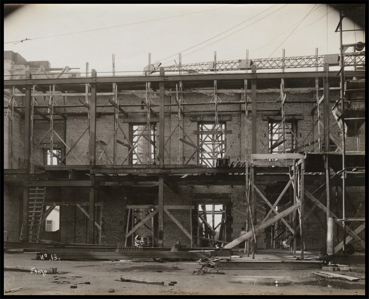 Interior photo of walls under constuction. The floors are just large steel beams with wood ladders between them.