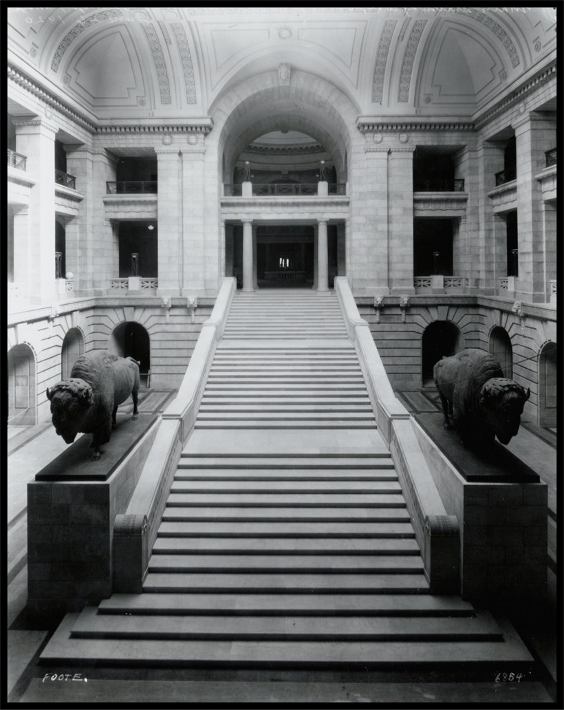 Photo of the completed Grand Staircase in the interior, with two large bison sculptures flanking the stairs.
