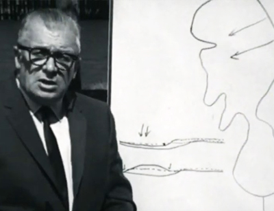 homme debout à côté d'une illustration du mécanisme du barrage