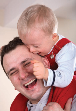 boy on man's shoulders, both laughing and smiling