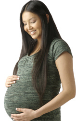 photo of pregnant woman smiling at her protruding abdomen